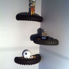 three black shelves with two football helmets on them