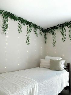 a bed with white sheets and lights on the wall above it, in a bedroom