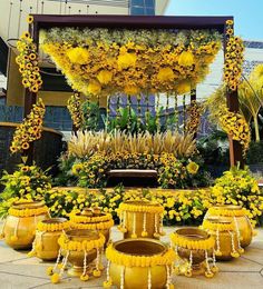 a bunch of flowers that are sitting in front of a gazebo and some potted plants