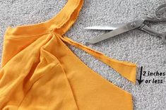 scissors are cutting through the fabric to make a halter top