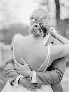 black and white photograph of a bride hugging her groom