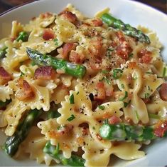 pasta with asparagus, bacon and parmesan cheese on a white plate