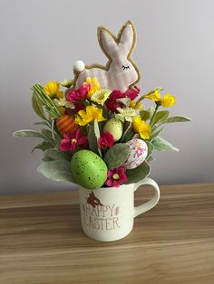 a coffee cup filled with flowers and easter decorations