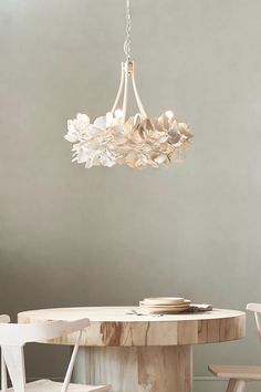 a white chandelier hanging over a wooden table