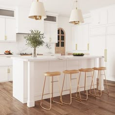 three stools sit at the center of a kitchen island in front of white cabinets