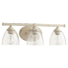 three light bathroom fixture with clear glass shades on the top and bottom lights in an off white finish