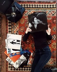 a woman laying on the floor holding up a poster