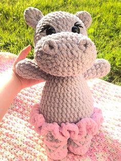 a crocheted hippo is sitting on a blanket