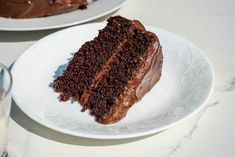 a slice of chocolate cake on a plate with a glass of milk next to it