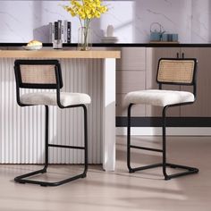 two white chairs sitting in front of a counter