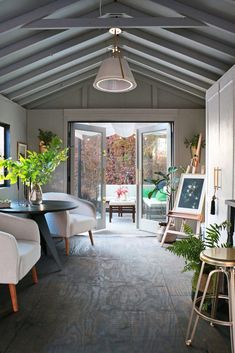 a living room filled with furniture and lots of plants on top of it's windows