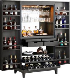 an open cabinet with bottles and glasses on it in front of a mirror filled with liquor