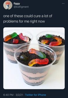 three plastic cups filled with dirt and gummy bears on top of each other,