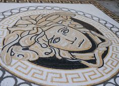 a mosaic on the ground with a woman's face