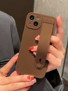 a woman holding up an iphone case with a phone holder attached to the back of it