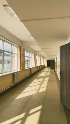 an empty hallway with large windows and no people in the room or on the floor