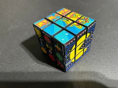 a rubik cube sitting on top of a table next to a black countertop