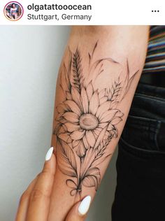 a woman's arm with a flower tattoo on the left side of her hand