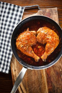 two pieces of meat in a pan on a wooden table