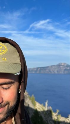 a man wearing a hat with the ocean in the background