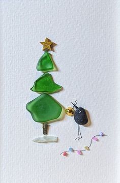 a christmas tree made out of green glass and gold ornaments on a white card with confetti streamers