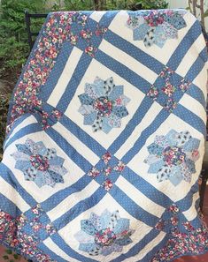 a blue and white quilt with flowers on it