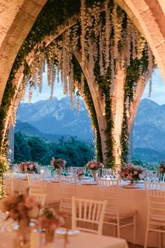 an outdoor dining area with tables and chairs set up for a formal function in the mountains