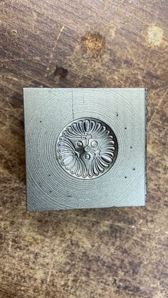 a metal object sitting on top of a wooden table