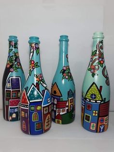 three colorful vases with houses painted on them