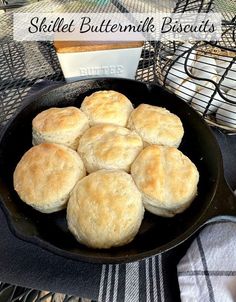 a skillet filled with biscuits sitting on top of a table