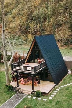 a small cabin in the middle of a field with stairs leading up to it's roof