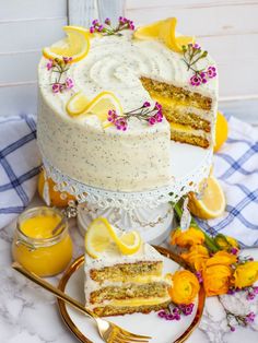 there is a cake with lemons and flowers on the table next to some forks