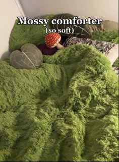 there is a green comforter on top of a bed with the words mossy comforter so soft