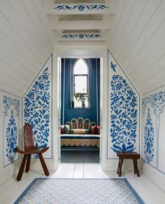 a blue and white room with two wooden chairs