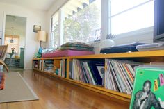 a bookshelf filled with lots of books on top of a hard wood floor