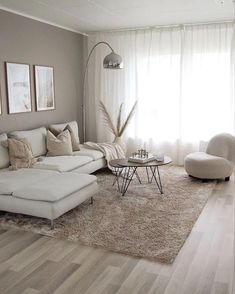 a living room filled with white furniture and lots of pillows on top of a rug