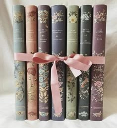 a row of books tied with a pink ribbon