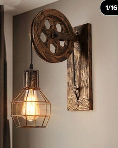 a light that is hanging from a wall next to a lamp fixture with a wooden wheel on it