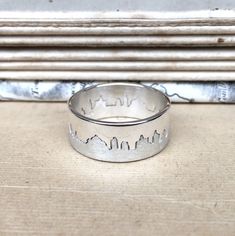 Two part interlocking hallmarked silver ring with matt and polished finishes based on your chosen city skyline. Makes a wonderful and unique keepsake of your honeymoon, special holiday or country of birth. Please specify a place name, and Hannah will work with you to create a silhouette before she starts making the ring. She can work from your own photograph if you have one of the panorama you would like or can source a suitable image with you. This ring is 8mm wide. Please ensure when selecting Cityscape Rings, Skyline Ring, Unique Silver Rings, Map Jewelry, Silver City, Place Names, City Skyline, Holiday Specials, Band Ring