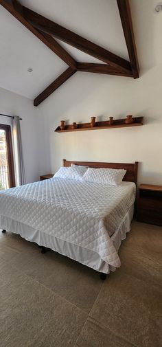 a bed with white sheets and pillows in a room