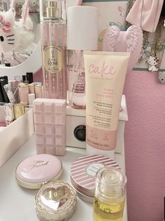 various beauty products are sitting on a counter in front of a pink wall and mirror