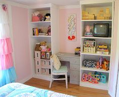 a child's bedroom with pink walls and white bookcases