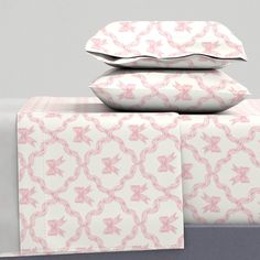 three pillows stacked on top of each other with pink bows and stars printed on them