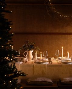 a table set for christmas with lit candles