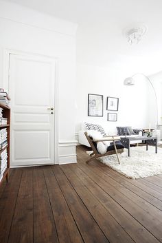 a living room with wood floors and white walls