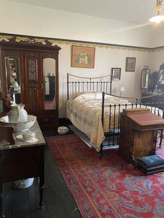 a bed room with a neatly made bed next to a dresser