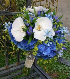 a blue and white bouquet sitting on top of a chair