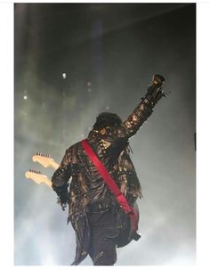 an image of a man that is on stage with his arms up in the air