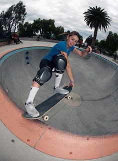 a woman riding a skateboard down the side of a ramp