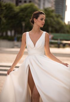 a woman in a white dress is standing on the street with her legs spread out